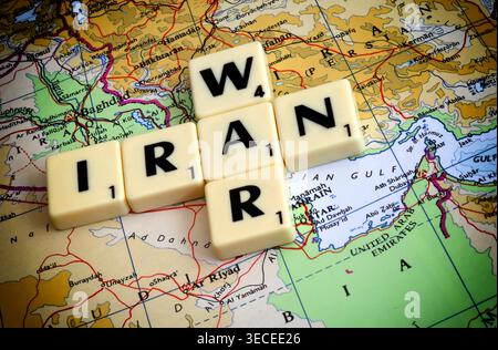 Image de concept de guerre en Iran avec des tuiles de lettres sur la carte du moyen-Orient près du détroit d'Ormuz, mettant en évidence les risques liés au transport maritime dans le Golfe Banque D'Images