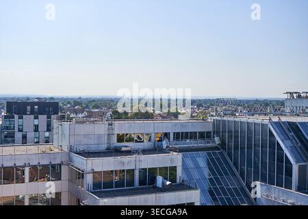 Vue aérienne de bâtiments de bureaux contemporains avec des façades en verre et des toits plats comportant des équipements mécaniques, des échelles et des plateformes de maintenance. Banque D'Images
