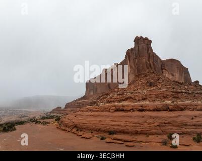 Vue aérienne d'une grande formation rocheuse de grès rouge sous un ciel brumeux et couvert dans l'Utah, USA. Banque D'Images