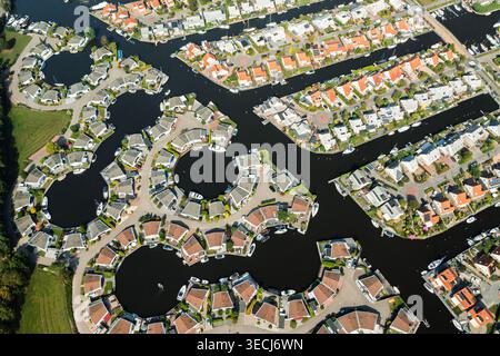 Vue aérienne de maisons résidentielles avec des toits rouges et gris disposés autour de canaux circulaires et de voies navigables avec des bateaux amarrés à Lemmer, Frise, Net Banque D'Images