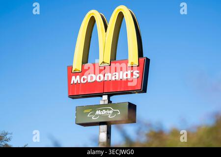Logo der Fast-Food-Kette McDonald s mit den bekannten Golden Arches und McDrive-Schild vor blauem Himmel. Aufnahme eines restaurants in Deutschland, Symbol für Systemgastronomie, Schnellrestaurant und globale franchise. Standort : Meinerzhagen, Deutschland. *** Logo de la chaîne de restauration rapide McDonald's avec le célèbre signe Golden Arches et McDrive devant un ciel bleu image d'un restaurant en Allemagne, symbole de la gastronomie du système, restaurant de restauration rapide et franchise mondiale lieu Meinerzhagen, Allemagne Copyright : MarcoxBader Banque D'Images