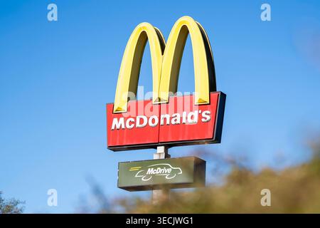 Logo der Fast-Food-Kette McDonald s mit den bekannten Golden Arches und McDrive-Schild vor blauem Himmel. Aufnahme eines restaurants in Deutschland, Symbol für Systemgastronomie, Schnellrestaurant und globale franchise. Standort : Meinerzhagen, Deutschland. *** Logo de la chaîne de restauration rapide McDonald's avec le célèbre signe Golden Arches et McDrive devant un ciel bleu image d'un restaurant en Allemagne, symbole de la gastronomie du système, restaurant de restauration rapide et franchise mondiale lieu Meinerzhagen, Allemagne Copyright : MarcoxBader Banque D'Images