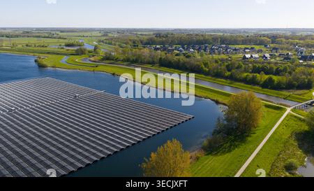 Vue aérienne de Sekdoornse Plas avec un large éventail de panneaux solaires flottants entourés de prairies verdoyantes et de maisons résidentielles à Zwolle, Overijss Banque D'Images