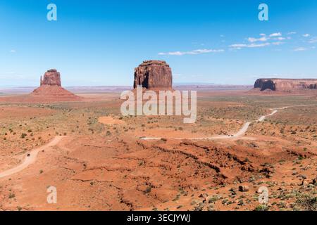 Vaste paysage de désert ensoleillé avec des Buttes emblématiques et des chemins de terre dans l'Utah Banque D'Images
