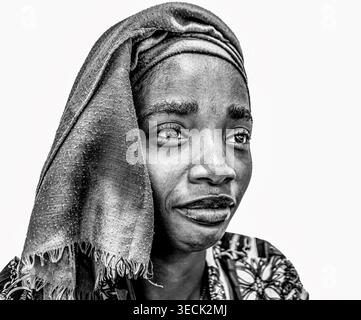 Portrait d'une jeune femme mahoraise portant des vêtements traditionnels et une peinture faciale blanche, photographiée sur fond noir. La mise en surbrillance de l'image Banque D'Images