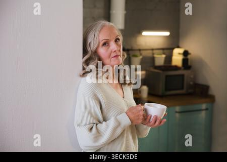 mode de vie sain des aînés. dépression. la santé émotionnelle. triste femme âgée boit du thé dans la cuisine à la maison Banque D'Images