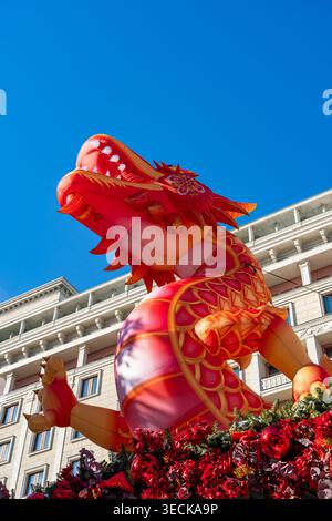 Vue en bas angle d'une décoration géante de dragon rouge et or surplombant les bâtiments de la ville sous un ciel bleu vif, célébrant le nouvel an chinois avec fest Banque D'Images