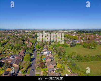 Aérien au-dessus de la ville résidentielle de banlieue avec de belles maisons, dans un quartier agréable au-dessus de East Preston et West Preston, West Sussex, Royaume-Uni, un jour de printemps ensoleillé. Banque D'Images
