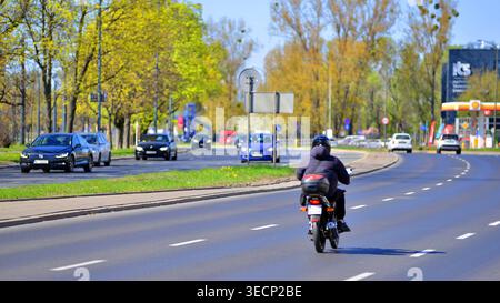 Varsovie, Pologne. 21 avril 2026. Circulation automobile à l'heure de pointe dans la zone de banlieue de la ville. Suburban avec des voitures et des bâtiments en arrière-plan. Banque D'Images