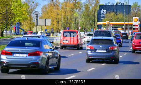 Varsovie, Pologne. 21 avril 2026. Circulation automobile à l'heure de pointe dans la zone de banlieue de la ville. Suburban avec des voitures et des bâtiments en arrière-plan. Banque D'Images