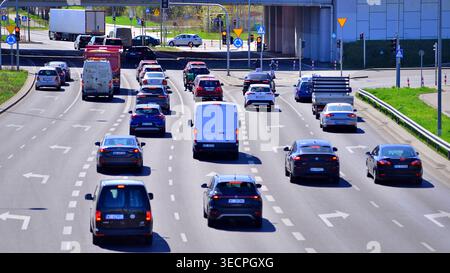 Varsovie, Pologne. 21 avril 2026. Circulation automobile à l'heure de pointe dans la zone de banlieue de la ville. Suburban avec des voitures et des bâtiments en arrière-plan. Banque D'Images