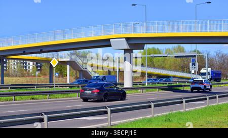 Varsovie, Pologne. 21 avril 2026. Circulation automobile à l'heure de pointe dans la zone de banlieue de la ville. Suburban avec des voitures et des bâtiments en arrière-plan. Banque D'Images
