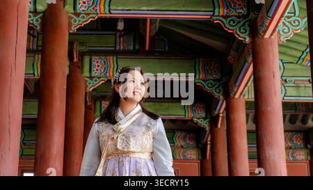 Une femme vêtue d'un beau hanbok, la tenue traditionnelle coréenne, se tient gracieusement au palais de Gyeongbokgung à Séoul, en Corée du Sud, mettant en valeur le culte Banque D'Images