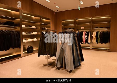 Intérieur de magasin de vêtements moderne avec porte-jeans et baskets Banque D'Images