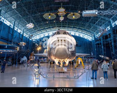Navette spatiale Discovery Udvar Hazy Front View Hangar Chantilly États-Unis | CHANTILLY, Virginie — la navette spatiale Discovery affronte les visiteurs de front à l'intérieur du hangar spatial James S. McDonnell au Steven F. Udvar-Hazy Center, ses propulseurs de contrôle de réaction montés sur le nez visibles sous les fenêtres du poste de pilotage. Discovery a effectué 39 missions entre 1984 et 2011, plus que tout autre orbiteur de la flotte de la NASA. Son train d'atterrissage et ses tuiles noires sous le ventre restent tels qu'ils étaient lors de l'atterrissage final en mars 2011. Banque D'Images