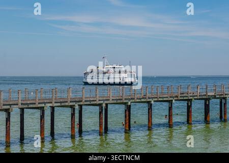 Oak Bluffs, Martha's Vineyard, ma, États-Unis-3 juillet 2025 : le ferry arrive au terminal de l'île et les gens nagent à la plage regardant le ferry. Banque D'Images