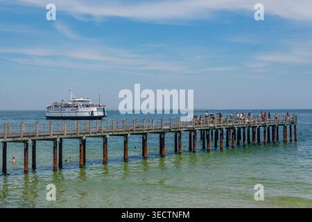 Oak Bluffs, Martha's Vineyard, ma, États-Unis-3 juillet 2025 : le ferry arrive au terminal de l'île et les gens nagent à la plage regardant le ferry. Banque D'Images