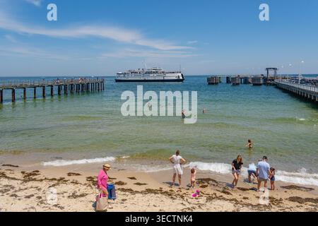 Oak Bluffs, Martha's Vineyard, ma, États-Unis-3 juillet 2025 : le ferry arrive au terminal de l'île et les gens nagent à la plage regardant le ferry. Banque D'Images