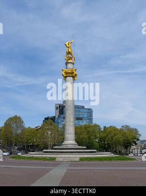 Plan vertical du monument de la liberté à Tbilissi, mettant en vedette la statue dorée George au sommet d'une haute colonne contre un ciel bleu. Géorgie, Tbilissi Banque D'Images