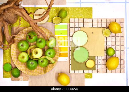 Composition vibrante à plat avec agrumes, kiwi, citron et orange avec des échantillons de palette de couleurs, des textures naturelles et des feuilles tropicales en éventail. Banque D'Images