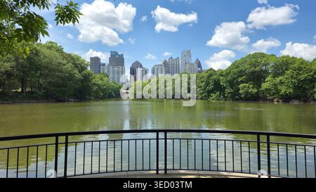 Horizon d'Atlanta vu de l'autre côté du lac dans Piedmont Park, Géorgie, États-Unis, par une journée ensoleillée, montrant la nature urbaine et le paysage urbain avec des arbres verts Banque D'Images