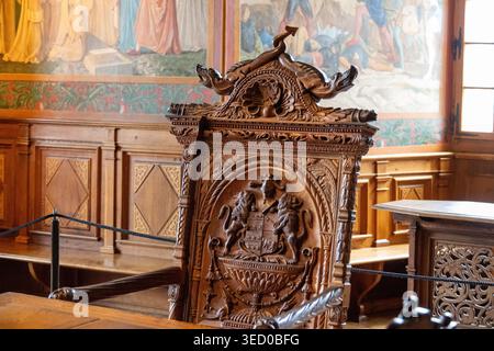 Gruyeres, Suisse - 13 juillet 24 : gros plan d'une chaise en bois sculpté ornée avec motif héraldique à l'intérieur du Château de Gruyeres, Gruyeres, Fribourg, Switz Banque D'Images