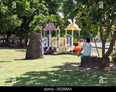 Père s'occupant de son fils dans un parc de la ville de Surin, Thaïlande Banque D'Images