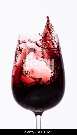 Liquide rouge éclaboussure dans un verre avec des glaçons à l'intérieur Banque D'Images