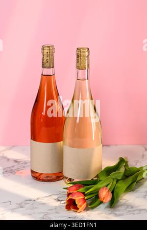 Deux bouteilles de vin et tulipes sur une surface en marbre Banque D'Images