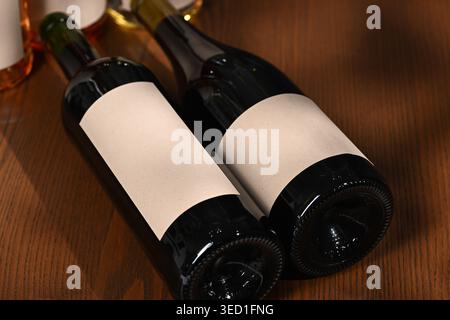 Deux bouteilles de vin foncées sans étiquettes reposant sur une table Banque D'Images