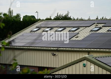 Toit de bâtiment industriel britannique avec panneaux solaires et puits de lumière Banque D'Images