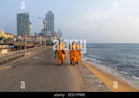 Moines bouddhistes marchant au bord de la mer au Galle face Green, Colombo, Sri Lanka Banque D'Images