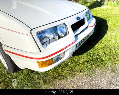 Vue rapprochée avant d'un Ford Sierra blanc classique sur un terrain en herbe montrant les détails des phares et du pare-chocs Banque D'Images