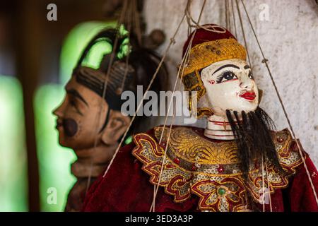 Gros plan de marionnettes birmanes avec des vêtements en velours rouge et des décorations dorées. L'image met en valeur l'artisanat local et peint à la main Banque D'Images