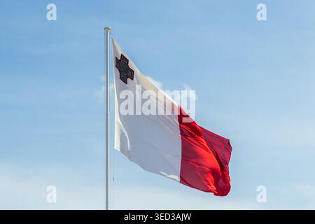 Valletta, Malte - 1er mai 2026, Malte drapeau agitant sur Un pôle contre ciel bleu clair avec emblème national visible Banque D'Images