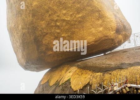 Gros plan sur le rocher doré au Myanmar. Le majestueux rocher de granit, entièrement recouvert de fines feuilles d'or par des dévots, repose dans un apparemment im Banque D'Images