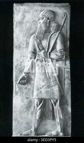 La légende de 1925 se lit comme suit : « relief en albâtre du guerrier de Sargon II de Chorsabad-dur Sarrukin au Louvre à Paris. » Sargon II était roi de l'Empire néo-assyrien de 722 av. J.-C. jusqu'à sa mort au combat en 705. Son palais de Chorsabad (également orthographié Khorsabad - et connu dans les temps anciens sous le nom de dur-Sharrukin) présentait des reliefs monumentaux en albâtre et des sculptures - une marque de fabrique de l'impérial néo-assyrien Découvert en 1843, le palais contenait plus de 200 pièces ornées de sculptures en pierre complexes qui documentaient les victoires militaires du roi et son statut religieux. Banque D'Images