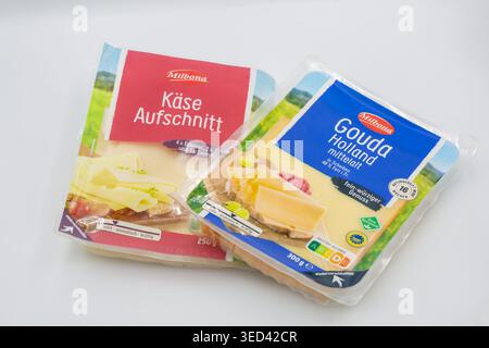 Kiev, Ukraine - 11 avril 2026 : deux paquets de tranches de fromage Milbona - rouge Kase Aufschnitt et bleu Gouda Holland variétés dans un emballage plastique transparent Banque D'Images