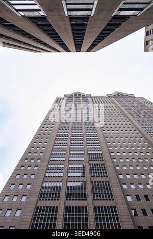 Les gens marchent sous les grands bâtiments du centre-ville de Chicago. La vue montre les détails des façades du bâtiment et le ciel au-dessus. Cette scène capture ci Banque D'Images