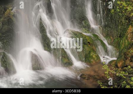 L'eau coule sur des rochers dans un ruisseau de montagne pendant la journée Banque D'Images