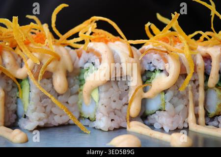 Rouleaux de sushi avec sauce et garnitures dans un restaurant Banque D'Images