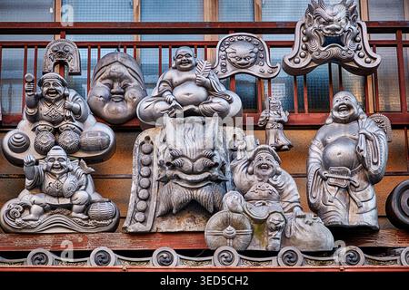 Un affichage de diverses figures métalliques est affiché à l'extérieur sur le mur au-dessus d'un magasin d'antiquités à Kyoto. Banque D'Images