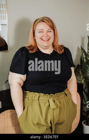 Femme taille plus rire, top noir et pantalon olive Banque D'Images