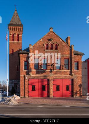 Ypsilanti, États-Unis - 12 février 2026 : caserne de pompiers historique en briques avec portes rouges de la baie et tour sous un ciel bleu clair, vue de jour sur la rue. Banque D'Images