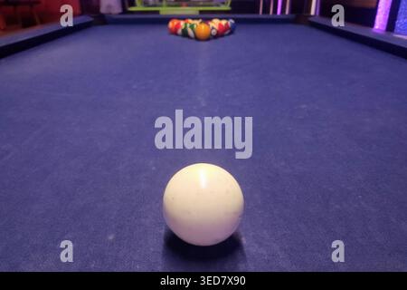 Boule de queue blanche de premier plan boules de billard colorées sur une table en feutre violet. Banque D'Images