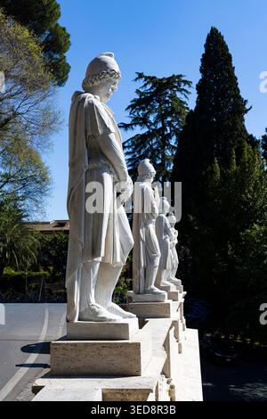Rangée de statues de figure médiévale en marbre blanc dans une perspective reculante sur les Plinths de travertin, Viale Gabriele d'Annunzio, Rome Banque D'Images