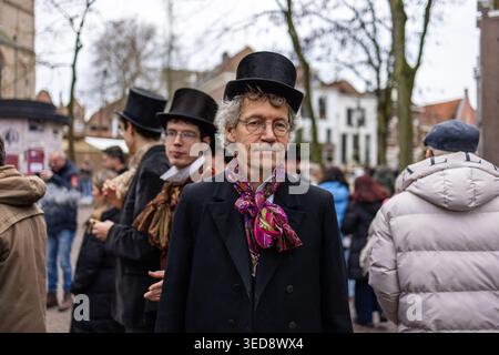 Deventer, Overijssel, pays-Bas - 14.12.2025 : homme dapper en haut-de-forme, lunettes et cravate colorée lors d'un événement de festival de costumes en plein air. Autre costum Banque D'Images