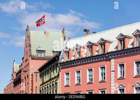 Oslo, 17 mai 2025 : drapeau norvégien flottant au-dessus des bâtiments historiques colorés dans le centre-ville - charme de l'architecture traditionnelle et l'esprit patriotique Banque D'Images