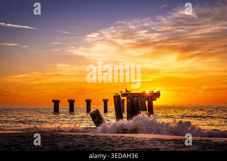 Le soleil se couche derrière les vestiges de la jetée à Boca Grande, Floride Banque D'Images
