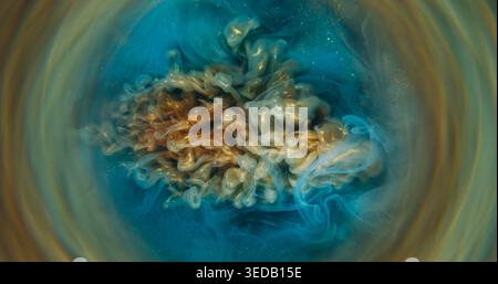 Flou du flux de peinture. Fumez de l'eau. Flou bleu jaune doré scintillant cercle de brouillard liquide tourbillonnant flotter sur fond abstrait. Banque D'Images